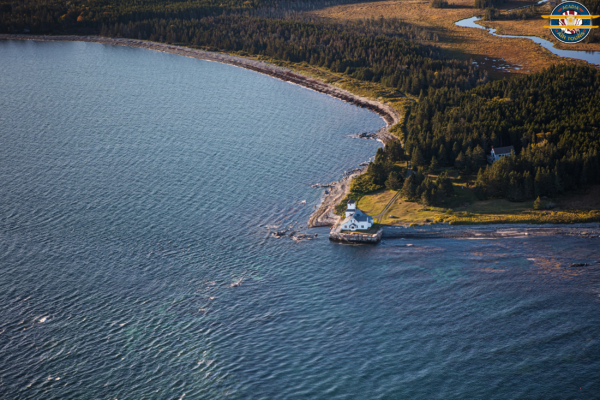 Scenic coastal house seen from Acadia Air Tours flight House on a rocky coastline surrounded by forest, seen from above during an Acadia Air Tours flight over Acadia National Park.