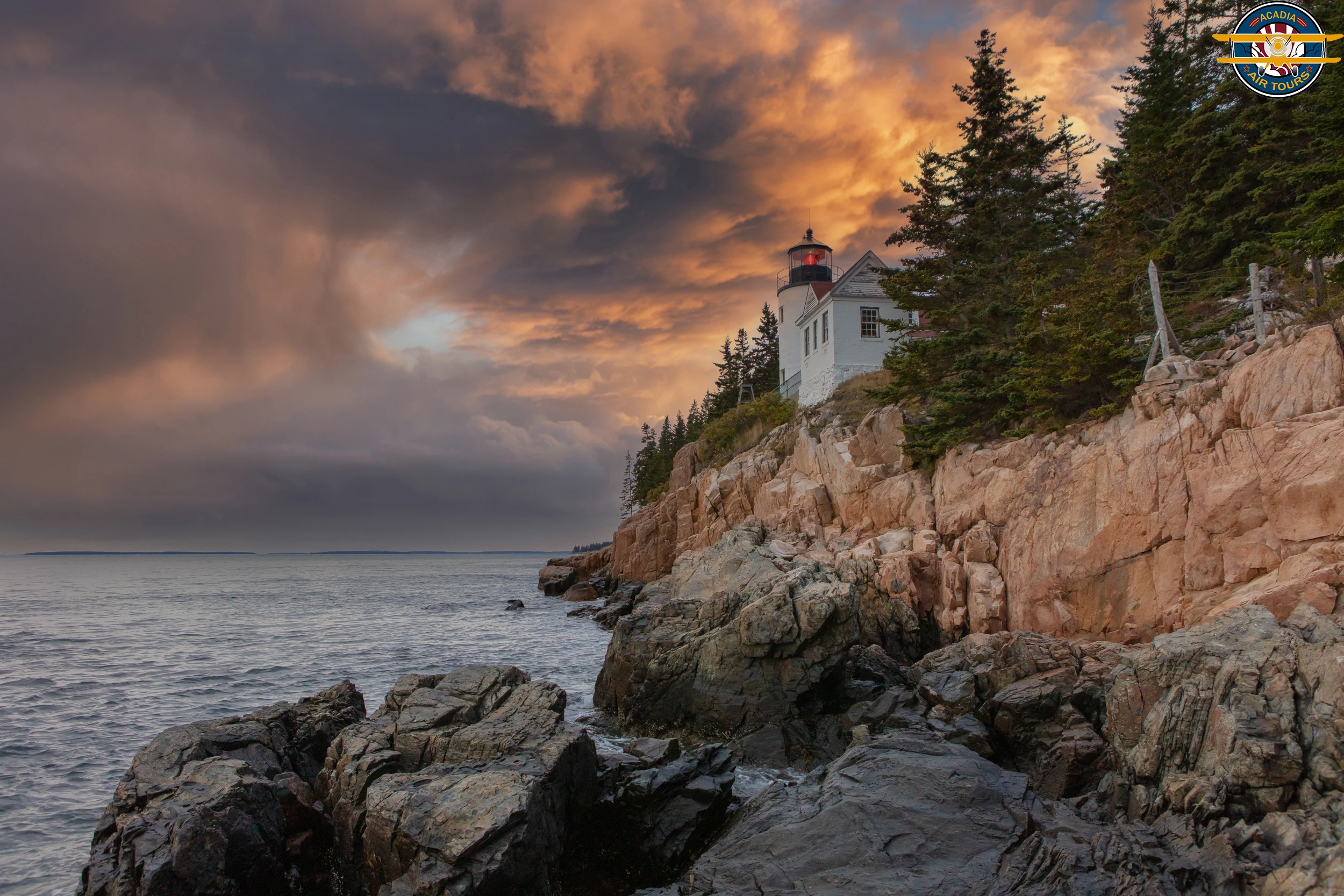 Bass Harbor Head Lighthouse at sunset, perched on a rocky cliff in Acadia National Park