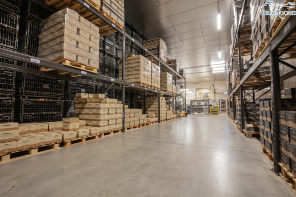 Wine case storage area – Packaging and logistics at Deux Roches Warehouse with stacked wine cases and metal crates at Deux Roches winery in Burgundy.