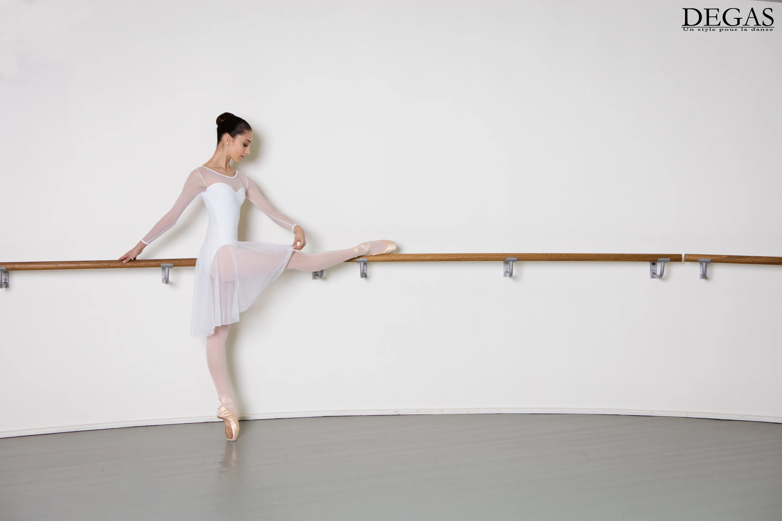 Ballet dancer in white dress warming up at the barre – photographed by a visual communication agency in Connecticut
