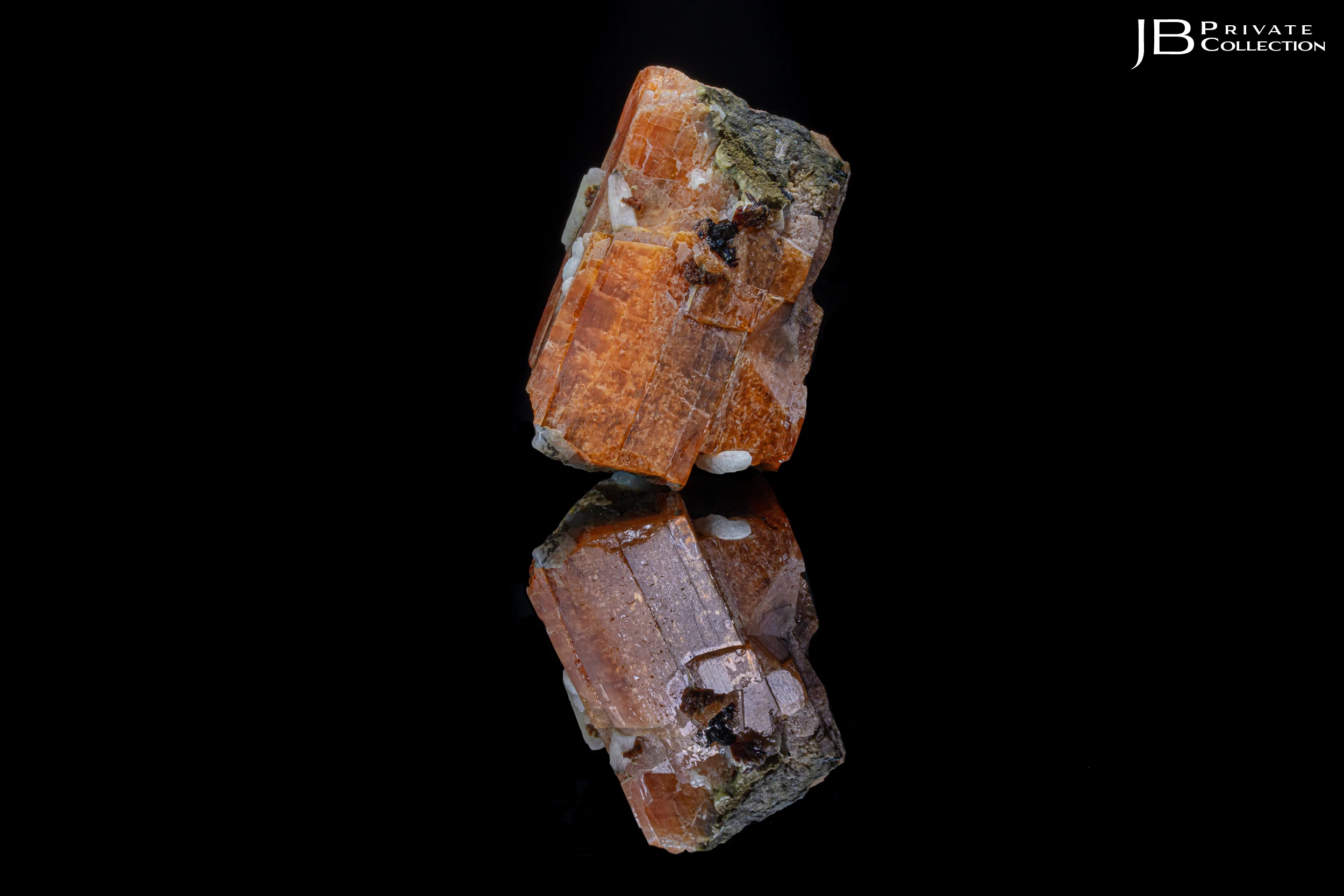 Serandite crystal from Poudrette Quarry, Quebec, with reflection on black vinyl background.