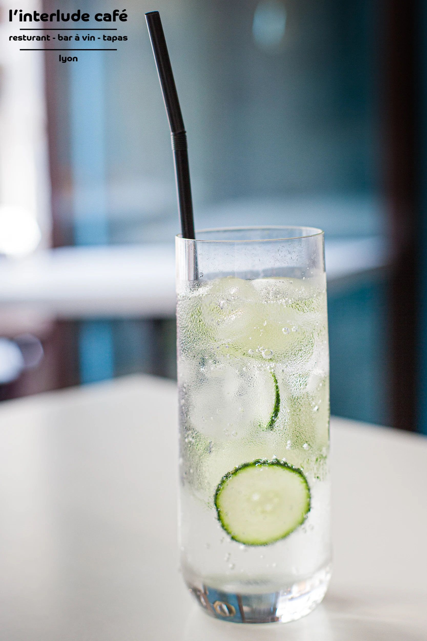Refreshing cucumber cocktail with ice and straw at Interlude Café in Lyon