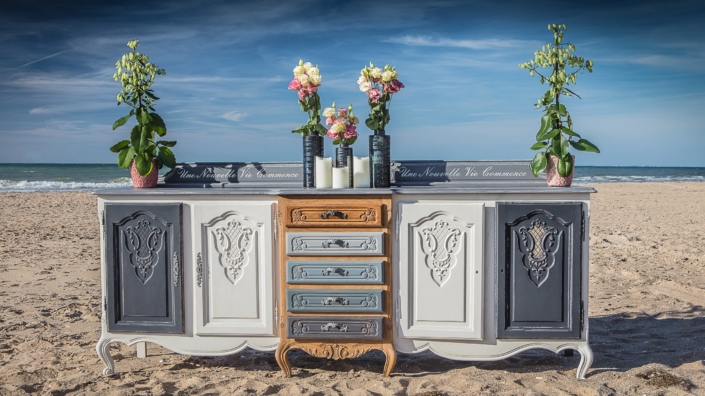 Two-tone patinated sideboard with floral decorations on the beach – Atelier Gris Mousse “Imagine Your Home”