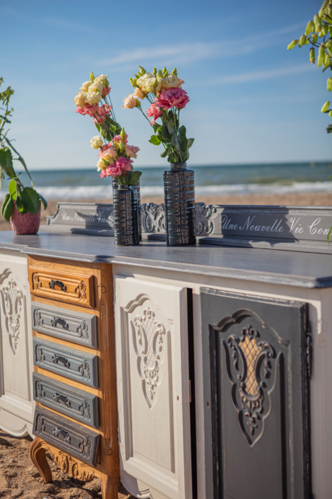 Hand-patinated buffet and floral vases styled on the beach – creative visual identity for interior design