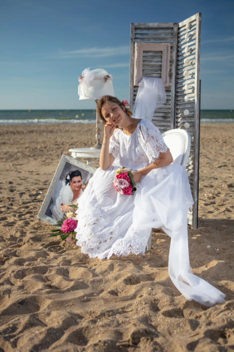 Bride seated on the beach with vintage decor, lace dress, flowers, and styled wedding elements — interior design identity by Atelier Gris Mousse.