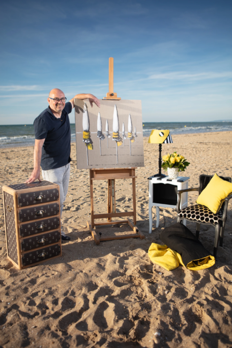 Artist Christian Bellec with painting and interior pieces styled on the beach – creative visual identity for interior design