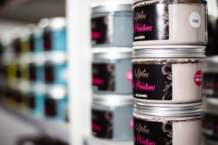 Satin finish paint jars displayed on boutique shelves – creative visual identity for interior design