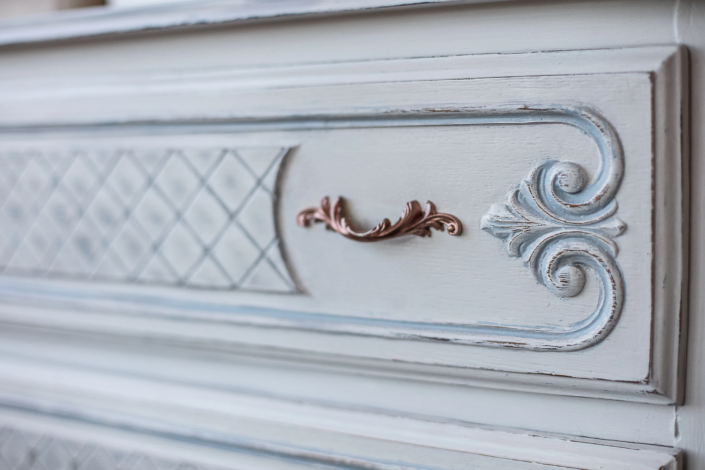 Close-up of patinated drawer with carved details and ornate handle – Atelier Gris Mousse