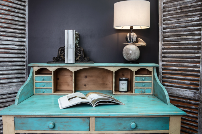 Patinated turquoise desk with decorative lamp and shutters – Atelier Gris Mousse studio scene