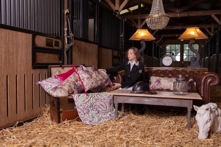 Rider arranging patterned cushions in stable setting — creative visual identity for interior design by Atelier Gris Mousse.