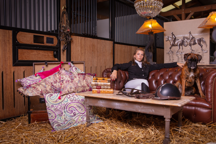 Equestrian-inspired decor with leather sofa, vintage cushions, and rider — creative visual identity for interior design by Atelier Gris Mousse.