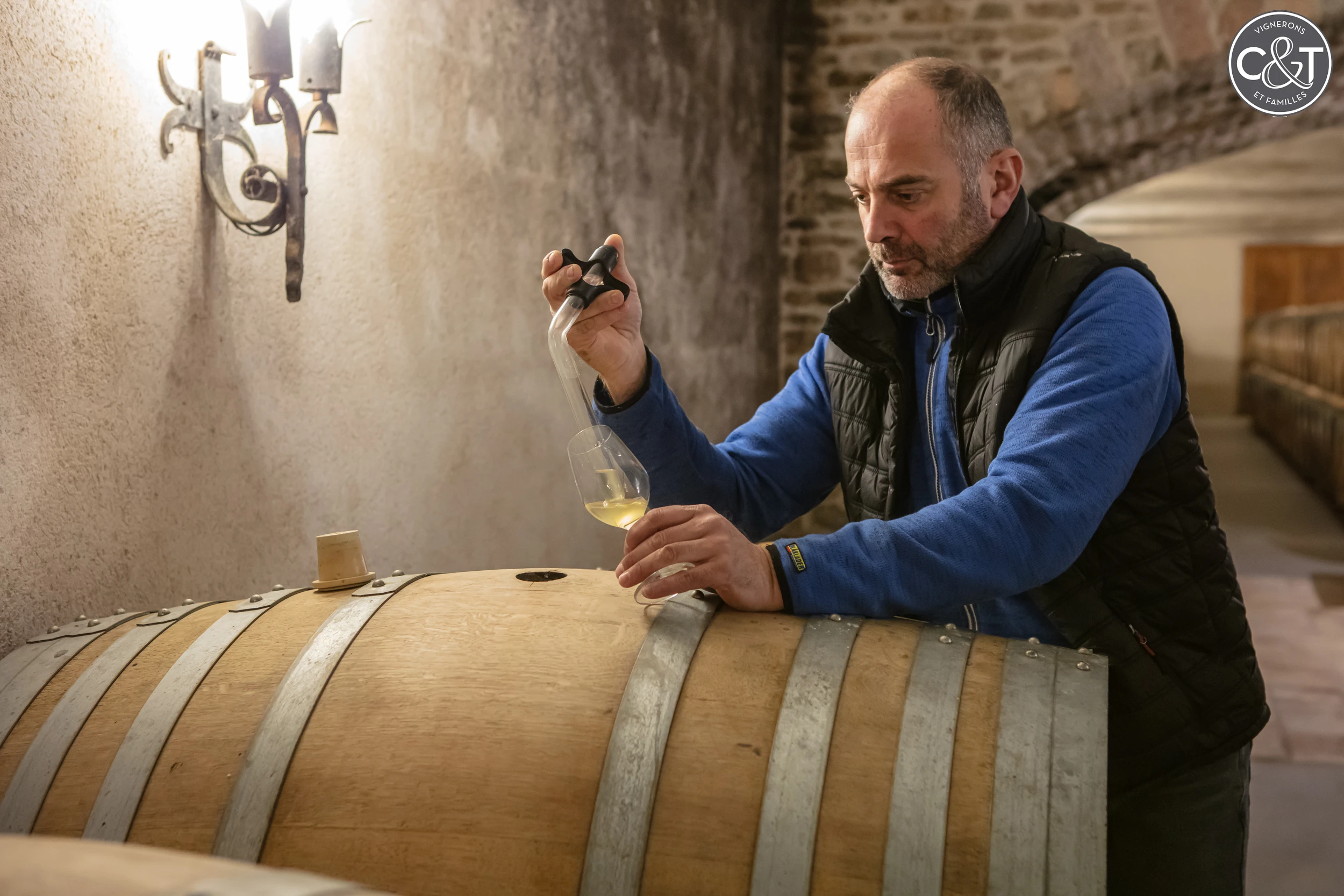 Winemaker sampling white wine from a barrel at Collovray & Terrier in Burgundy.