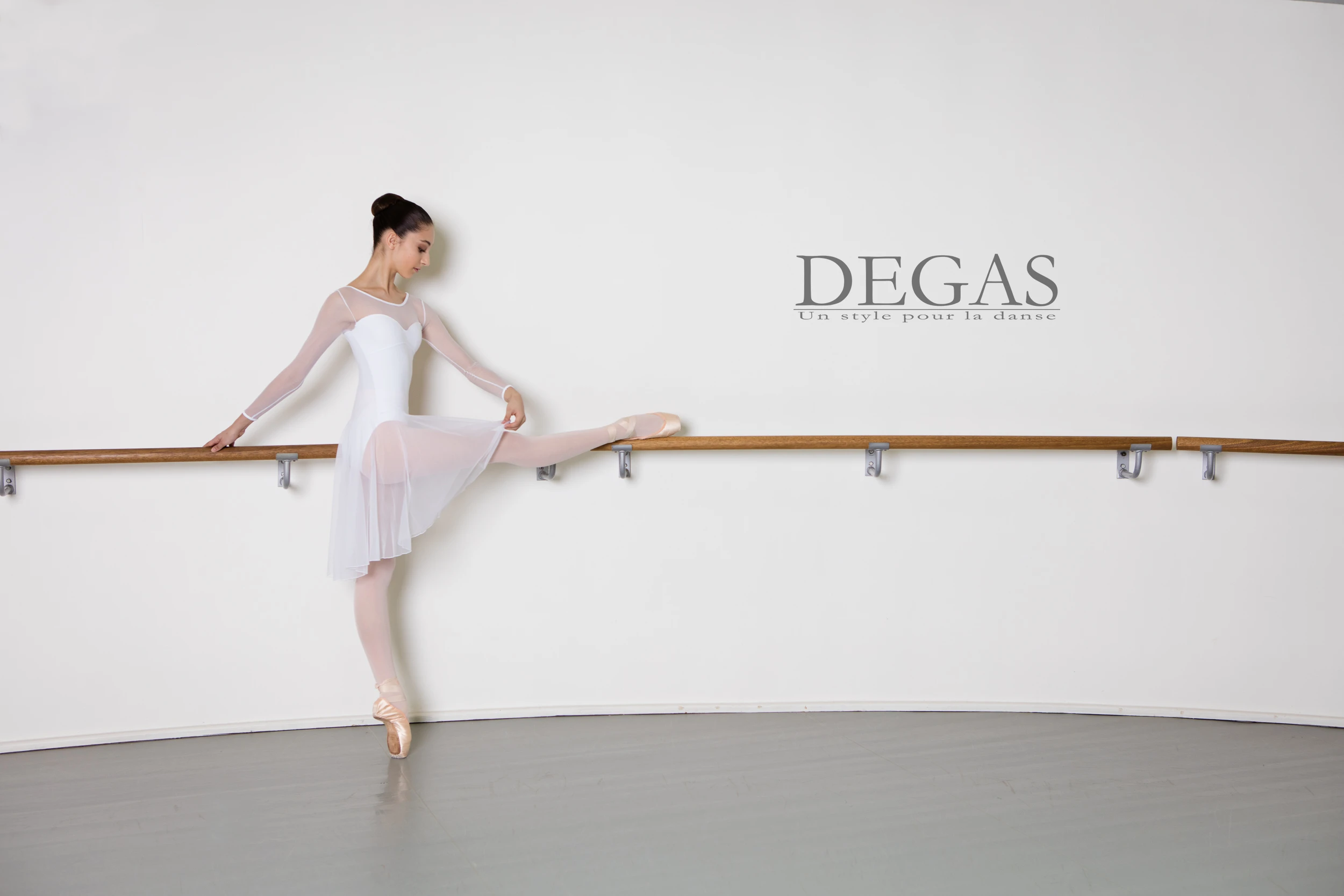 Ballet dancer in white dress warming up at the barre – photographed by a visual communication agency in Connecticut
