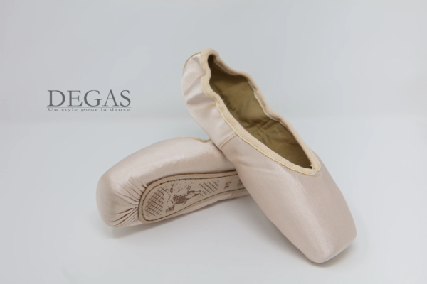 Handmade satin pointe shoes by Degas — professional ballet footwear. Pair of Degas pink satin pointe shoes with split soles and long ribbons — handmade professional ballet footwear.