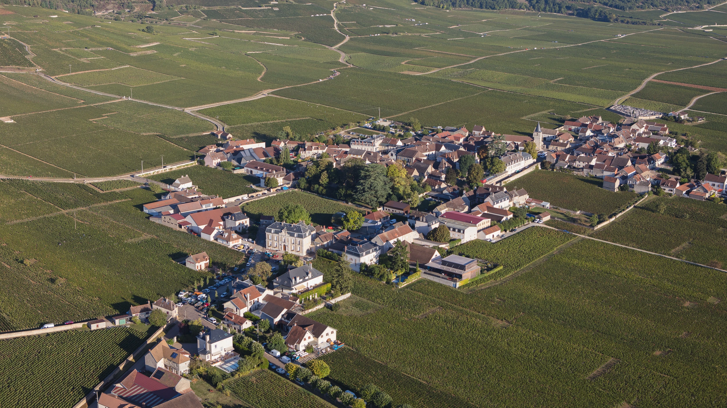 Aerial view of Vosne-Romanée village surrounded by vineyards in Côte de Nuits, Burgundy.