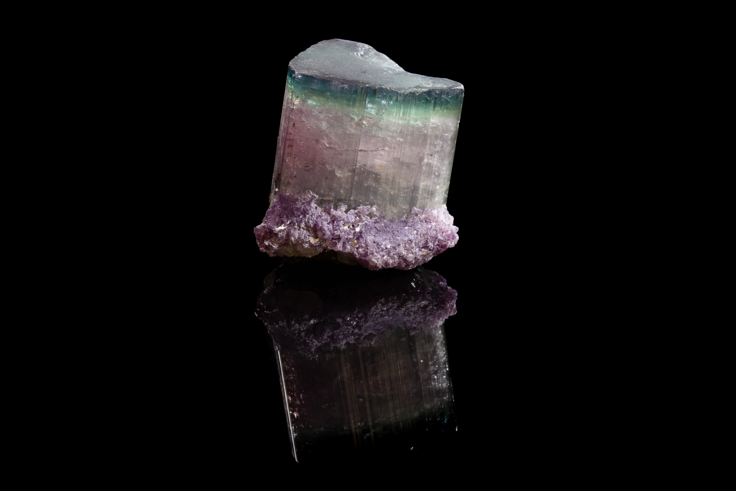 Color-zoned tourmaline crystal from California, USA – mineral photography on black vinyl background (2023)