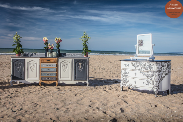 Restyled sideboard in grey, white and natural wood, lettered "Une Nouvelle Vie Commence", set with flowers and candles