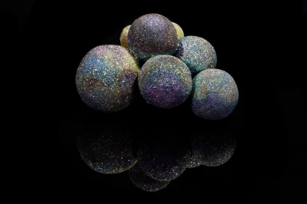 Cluster of five chalcopyrite spheres with an iridescent surface shifting through violet, blue and gold, mirrored on black vinyl, China