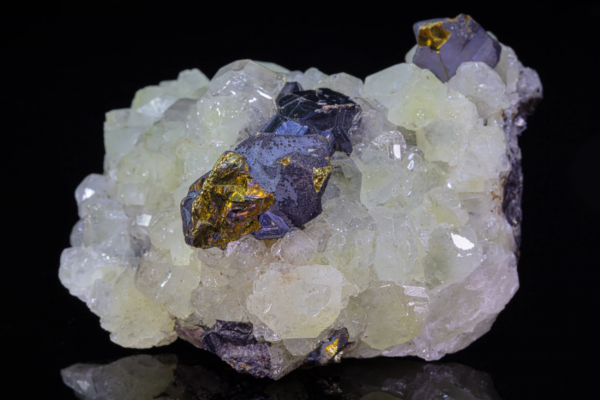 Iridescent gold and violet chalcopyrite crystals resting on a bed of pale green datolite, Mexico