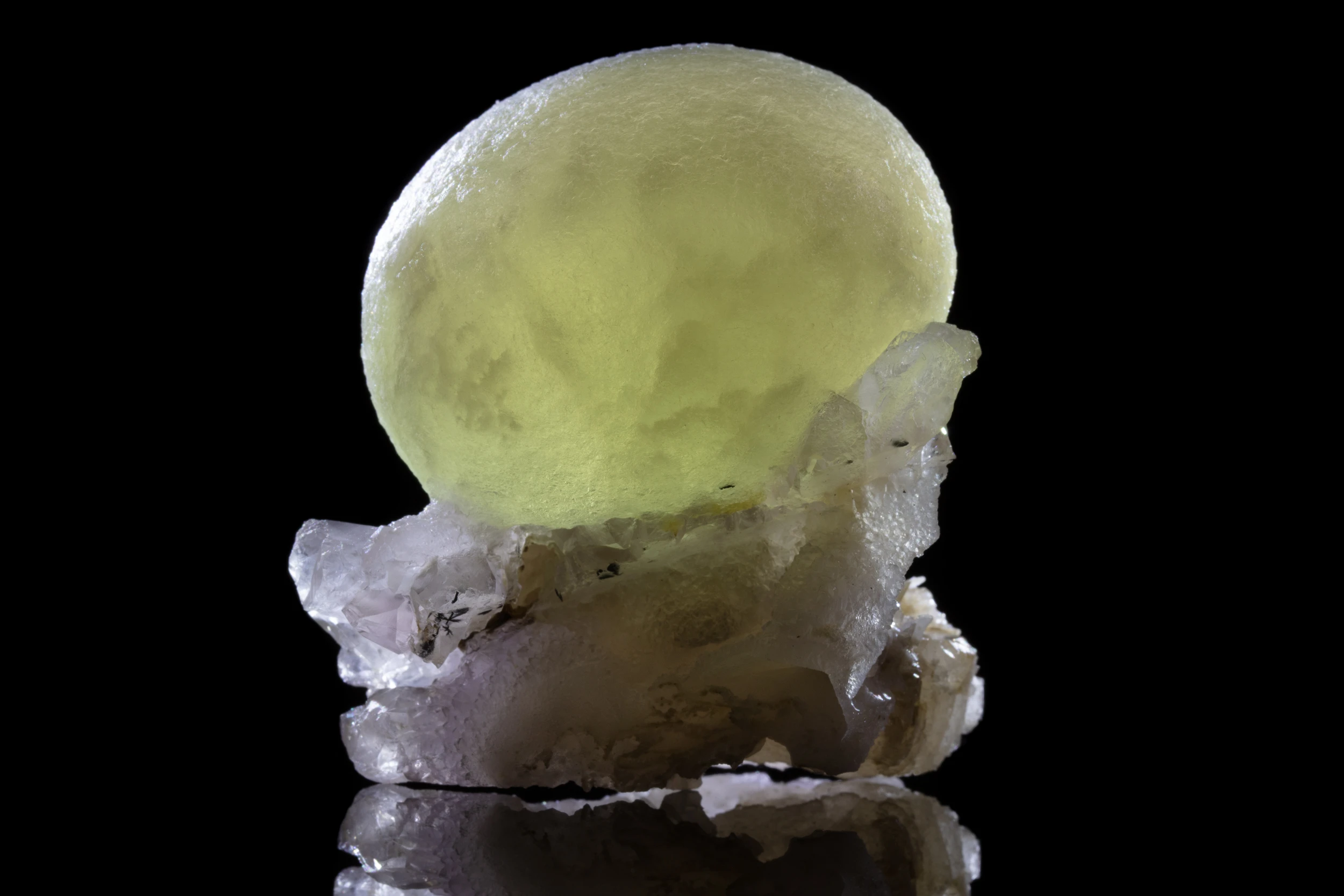 Single yellow-green botryoidal fluorite sphere resting on a bed of small quartz crystals, mirrored on black vinyl, India