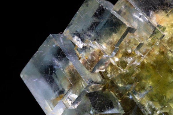 Macro view of stepped translucent fluorite cubes, pale green passing to yellow, with mineral inclusions visible inside the crystals, La Barre Mine, France