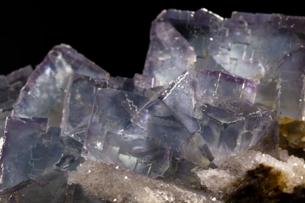 Large pale violet and blue fluorite cubes with stepped growth faces, sitting on a bed of small quartz crystals, Spain